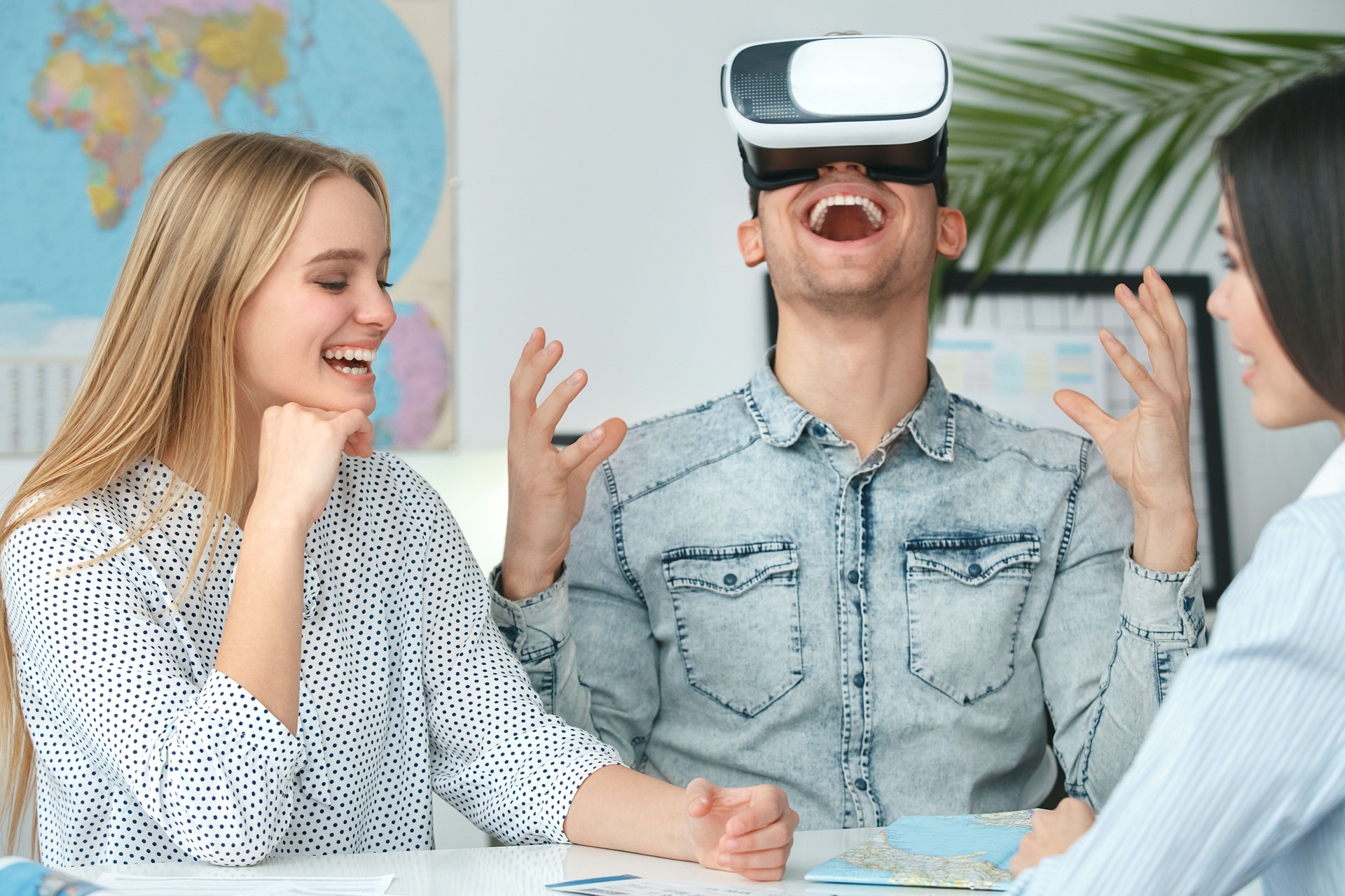 Young couple in a tour agency communication with a travel agent travelling concept virtual reality headset impressed